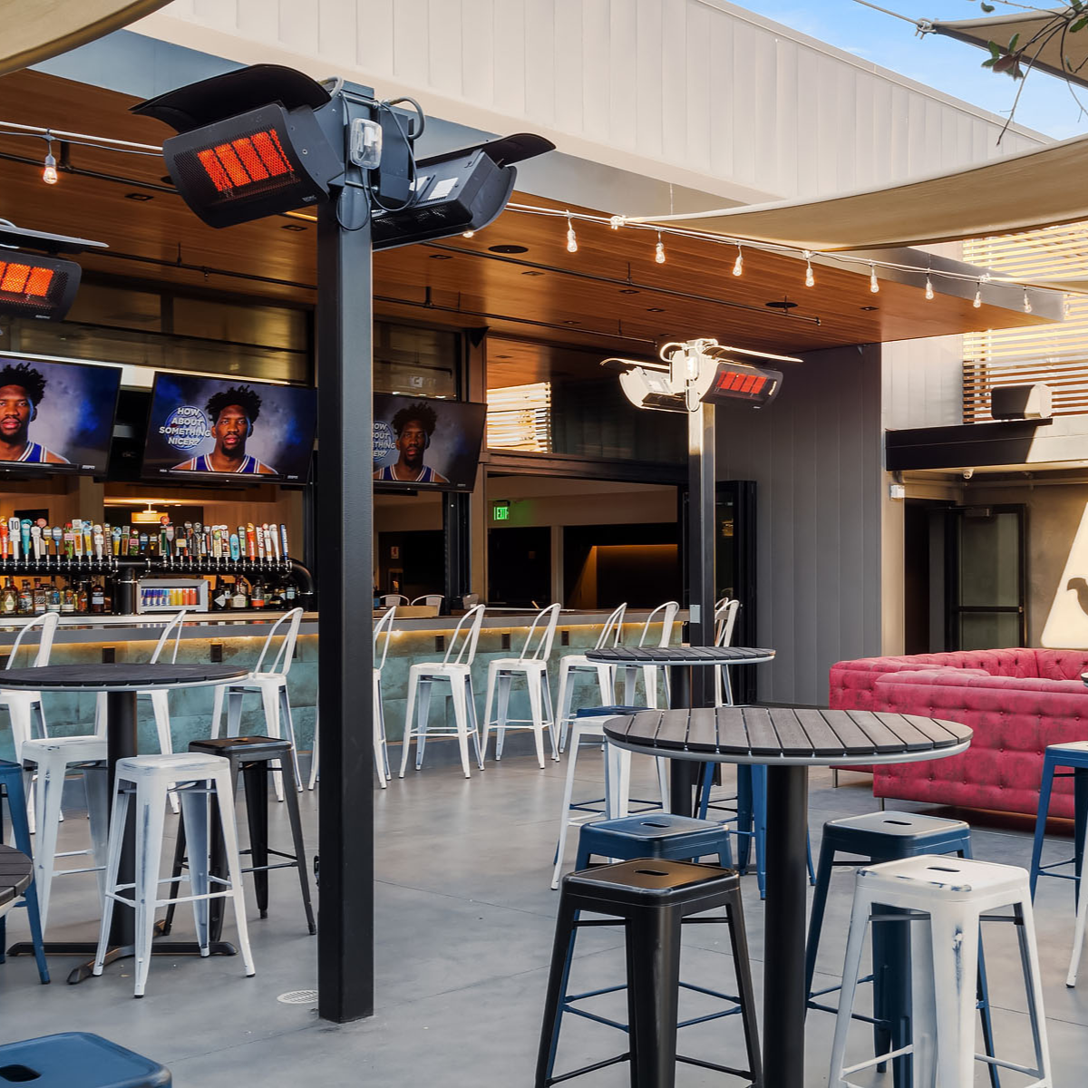 Calefactores Bromic Tungsten 500 montados en postes en bar moderno con terraza al aire libre